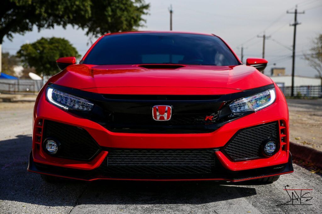 Red Honda Civic Type R, front view, black grille, daytime.