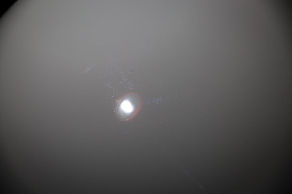 Bright light source in a hazy gray gradient background.