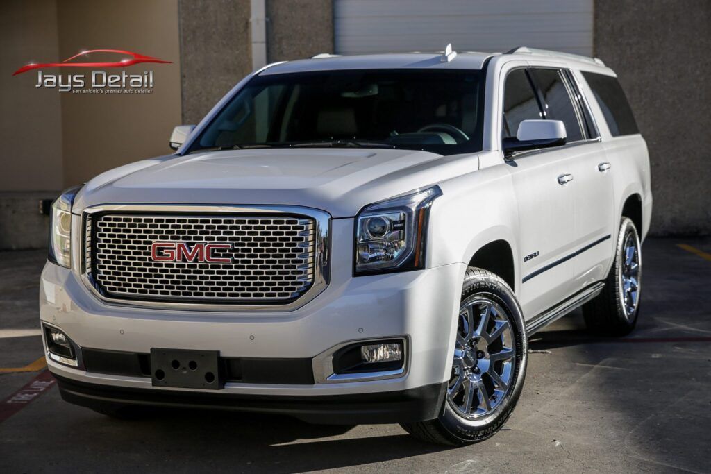 White GMC Yukon SUV parked outside with chrome accents.