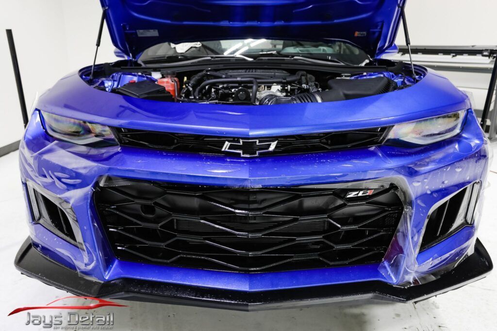 Blue Chevrolet Camaro with hood up, showing engine.