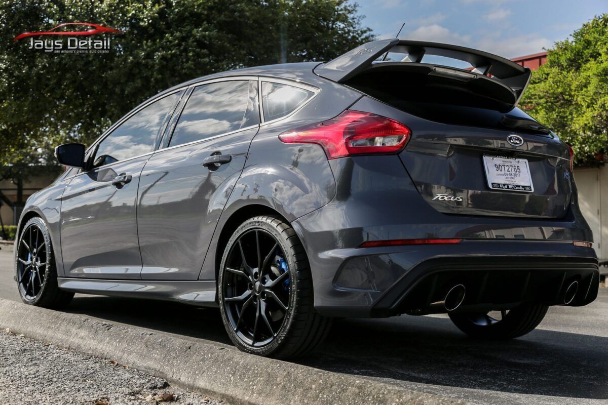 Gray Ford Focus RS with black wheels parked on a street.