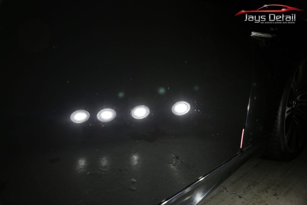Comparison of a car's black paint: dull on the left, polished and reflective on the right, with light reflections.