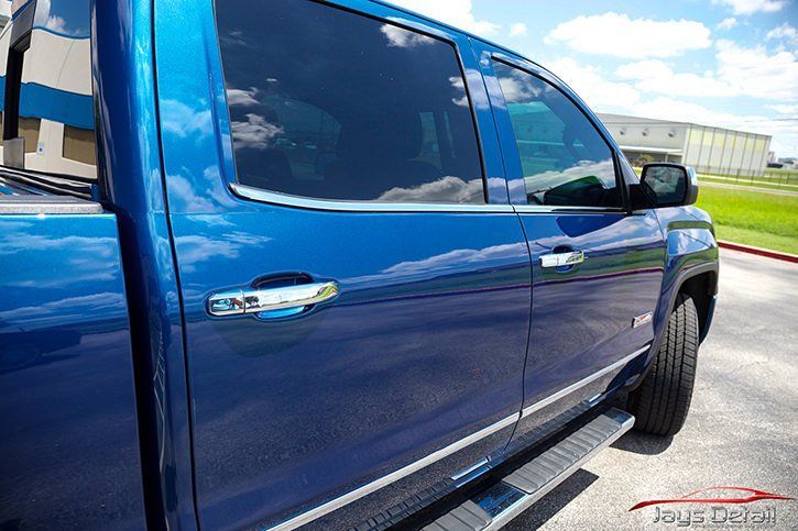 Blue pickup truck with tinted windows and chrome accents parked outdoors.