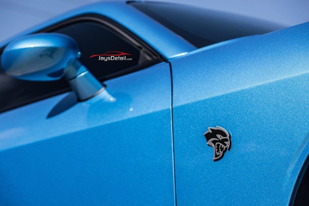 Blue Dodge Challenger with a Hellcat emblem.