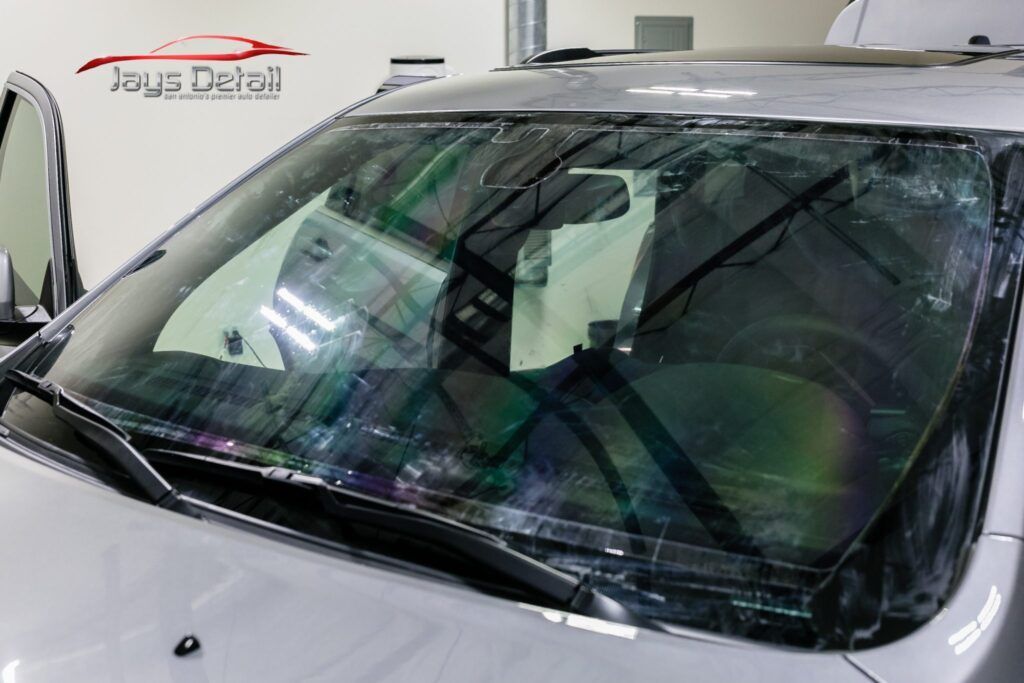 Windshield of a car with water streaks, viewed up close.