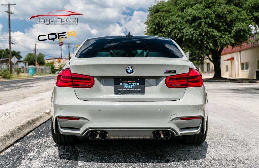 Rear view of a silver BMW M3 sedan parked on a street.