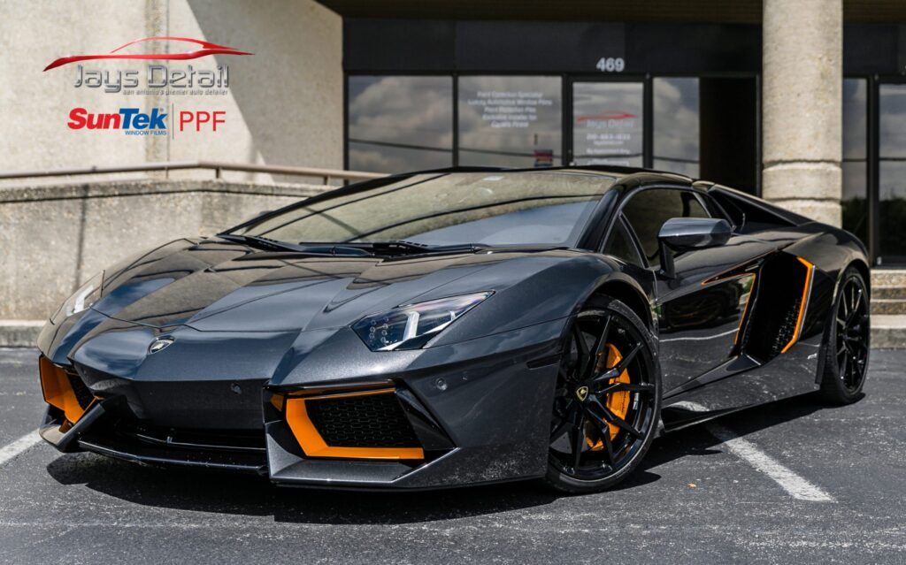 Gray Lamborghini with orange accents parked in front of a building.