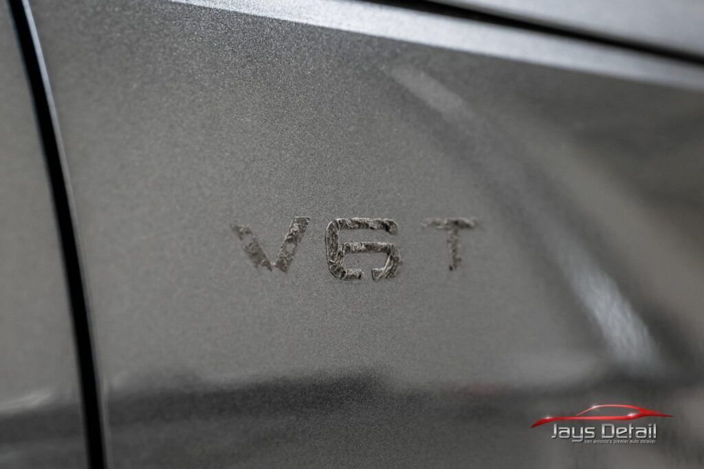 Close-up of a car's metallic grey side, showing