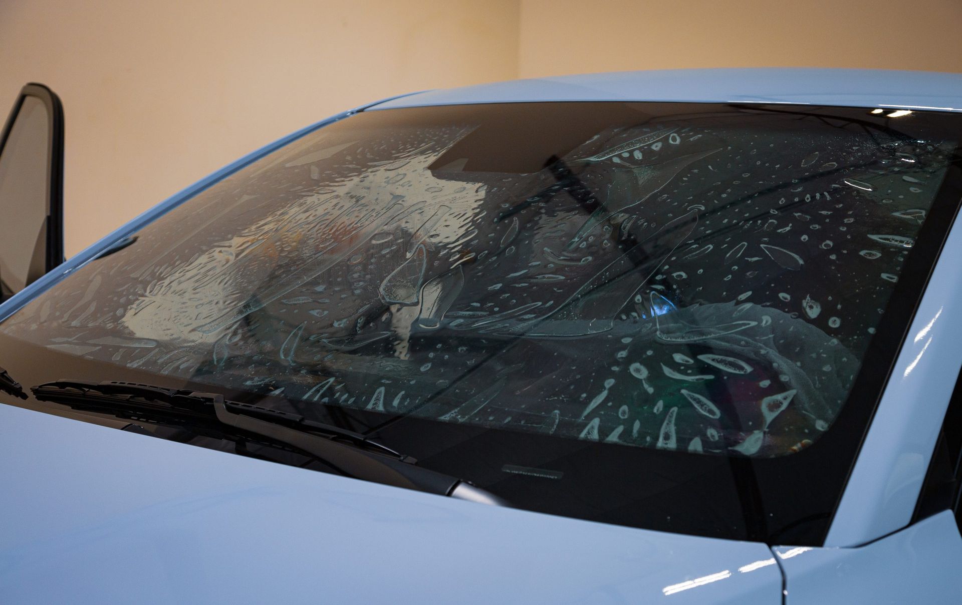 Car windshield with protective film being applied.