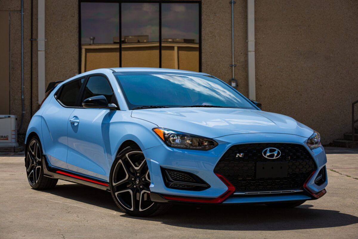 Blue Hyundai Veloster N sports car parked in front of a building.