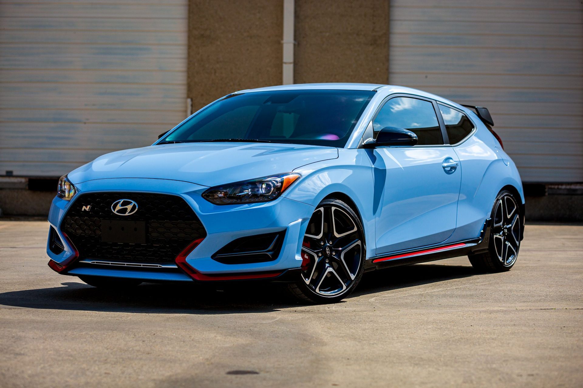 Blue Hyundai Veloster N sports car parked on concrete.