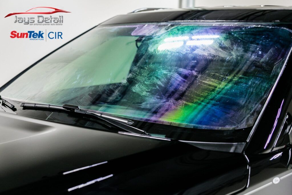 A black car with rainbow-tinted film on its windshield, Jay's Detail and SunTek logos are visible.