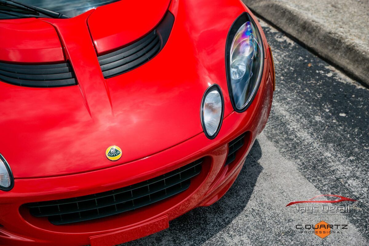 Red Lotus sports car, close-up of the front with the Lotus logo.