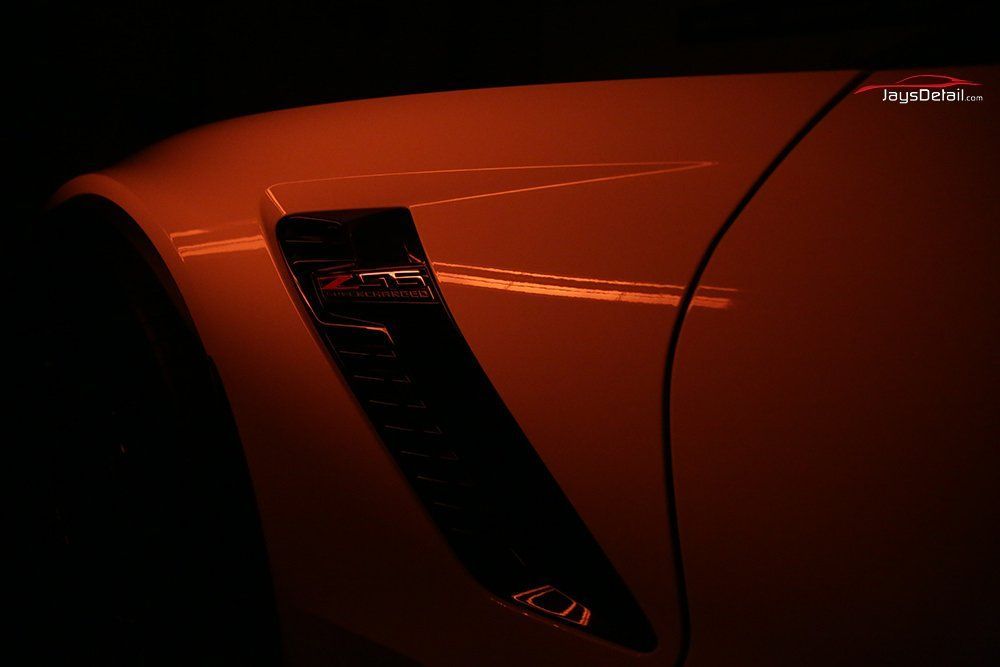 Orange car fender with a black vent.