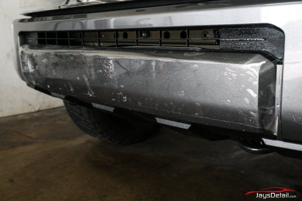 Silver car bumper with protective film applied.