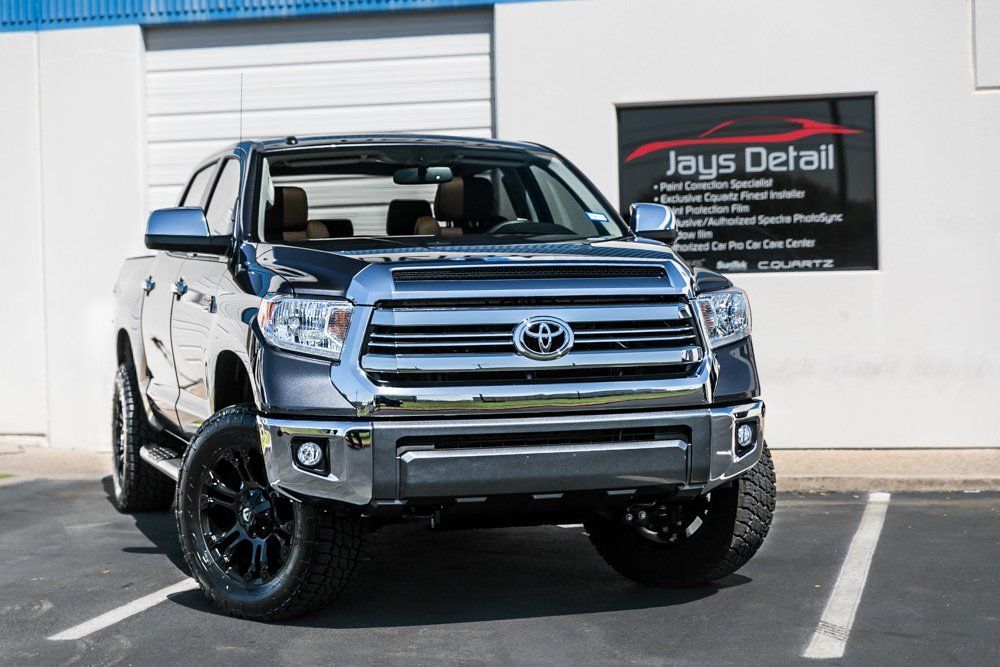 Dark gray Toyota Tundra pickup truck with black wheels parked outside Jay's Detail business.