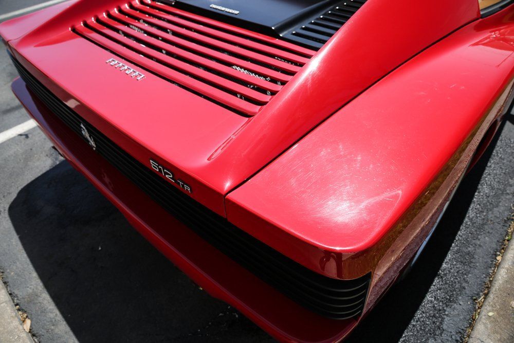 Red Ferrari Testarossa rear end with horizontal black slats.