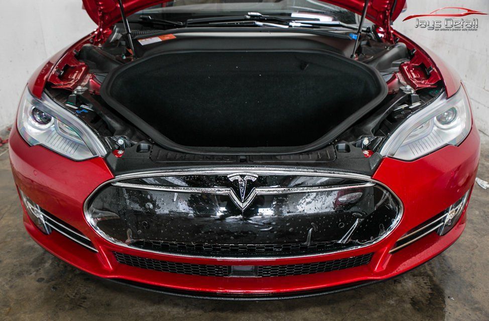 Red Tesla Model S with the front trunk open.