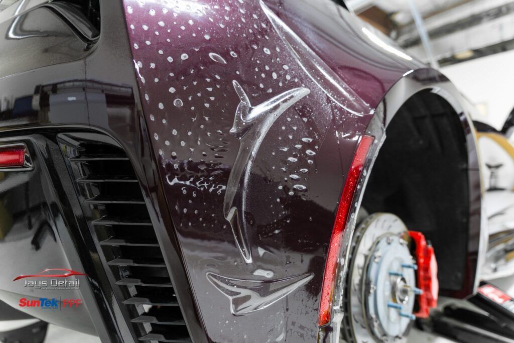 Car door covered in soapy solution during paint protection film installation.