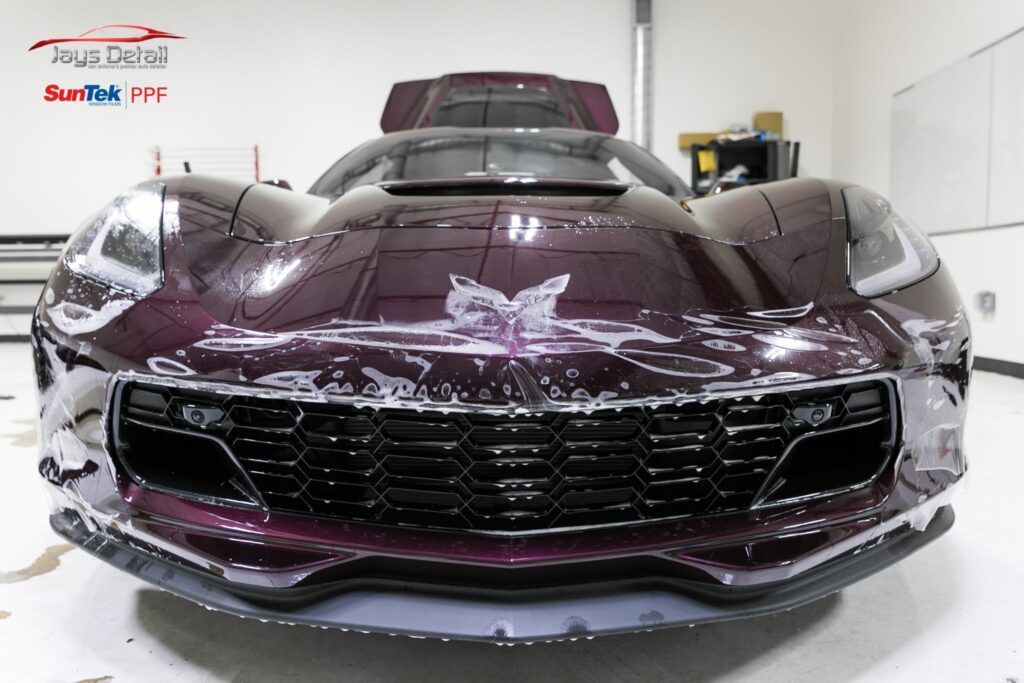 Purple sports car being wrapped in protective film.