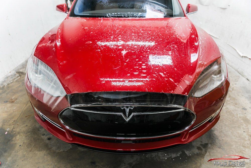 White car's rear quarter panel, with fuel door and air vent visible.