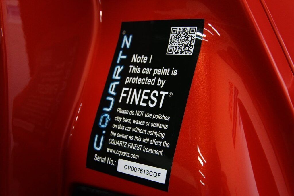 Black sticker on red car with text