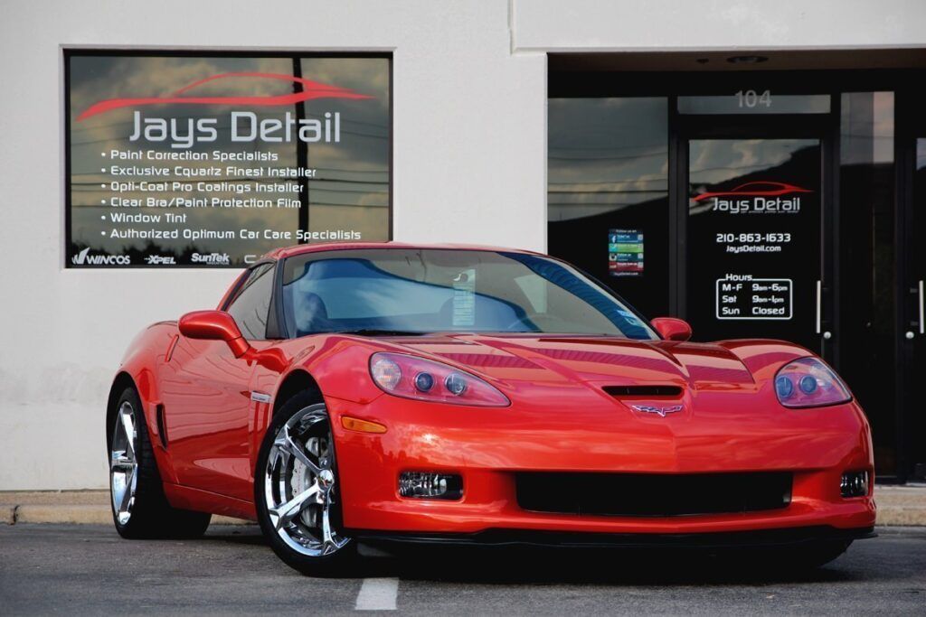 Red Corvette sports car parked in front of Jay's Detail car wash.