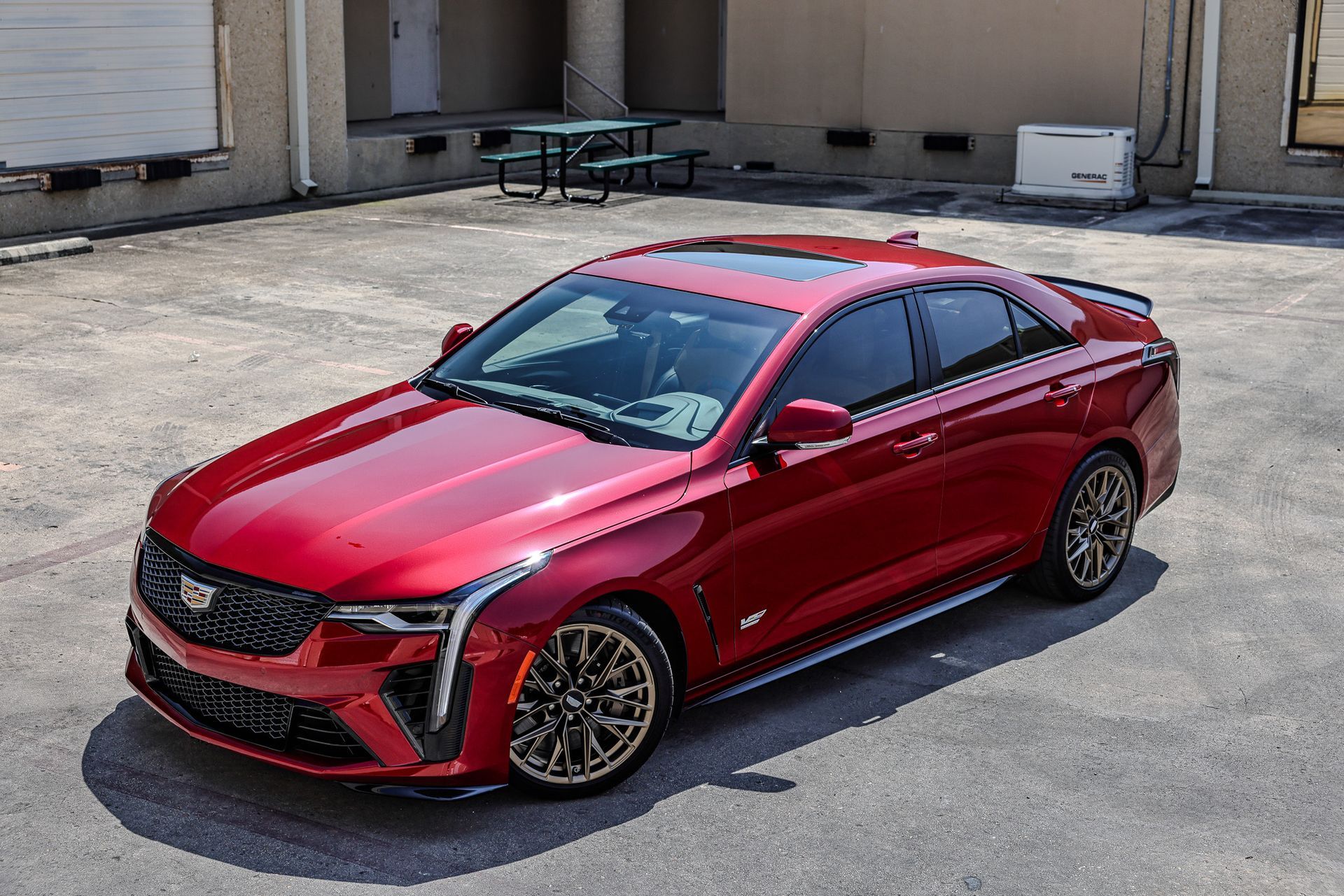 Red Cadillac sports sedan parked on a concrete surface.
