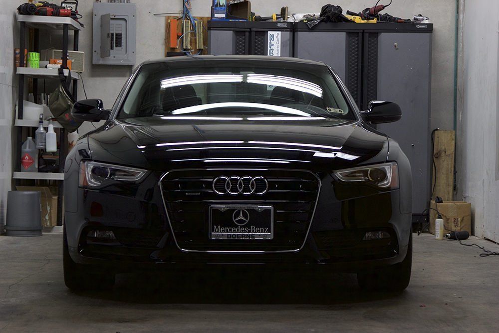 Black Audi A5 parked in a garage, facing the camera.