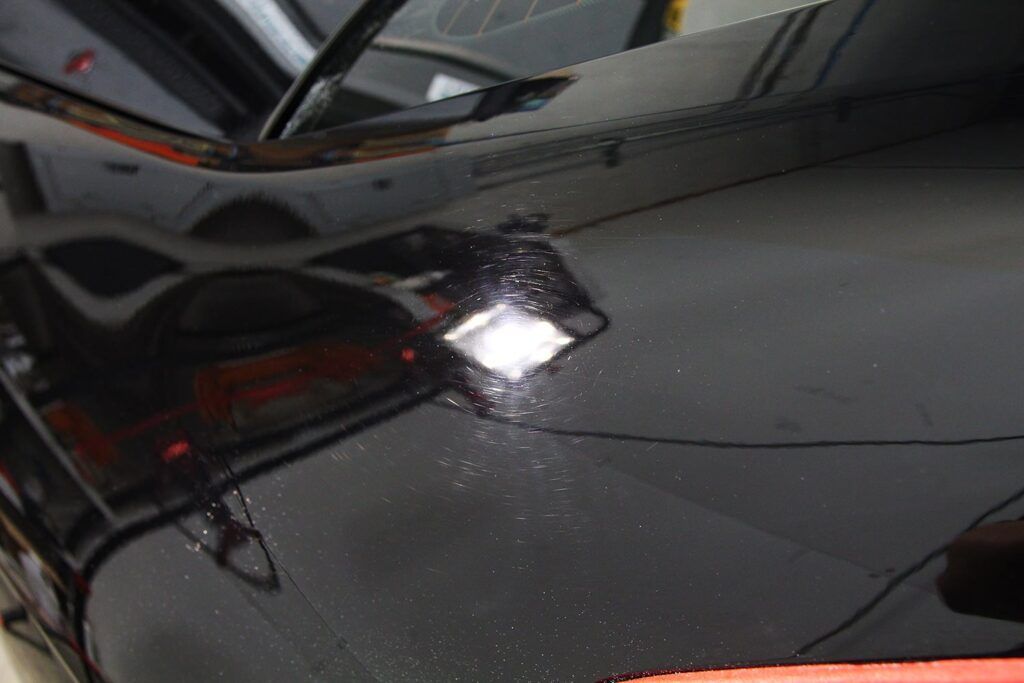 Blue truck with windshield wipers cleaning a dirty windshield.