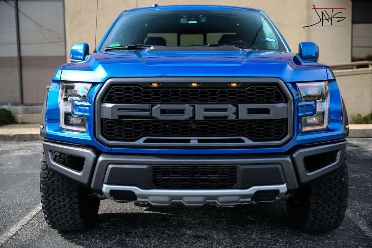 Blue Ford Raptor truck, front view, black grill with 
