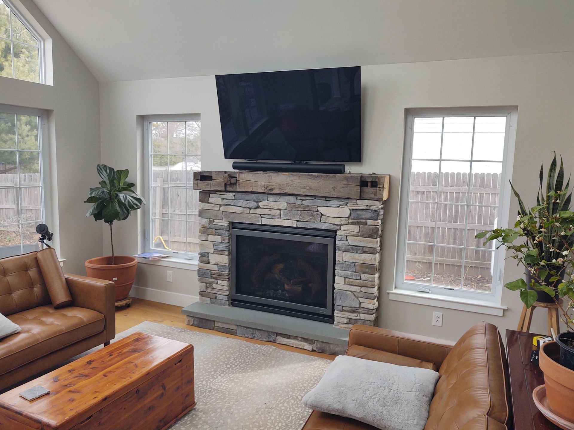 A living room with a fireplace , couch , coffee table and television.