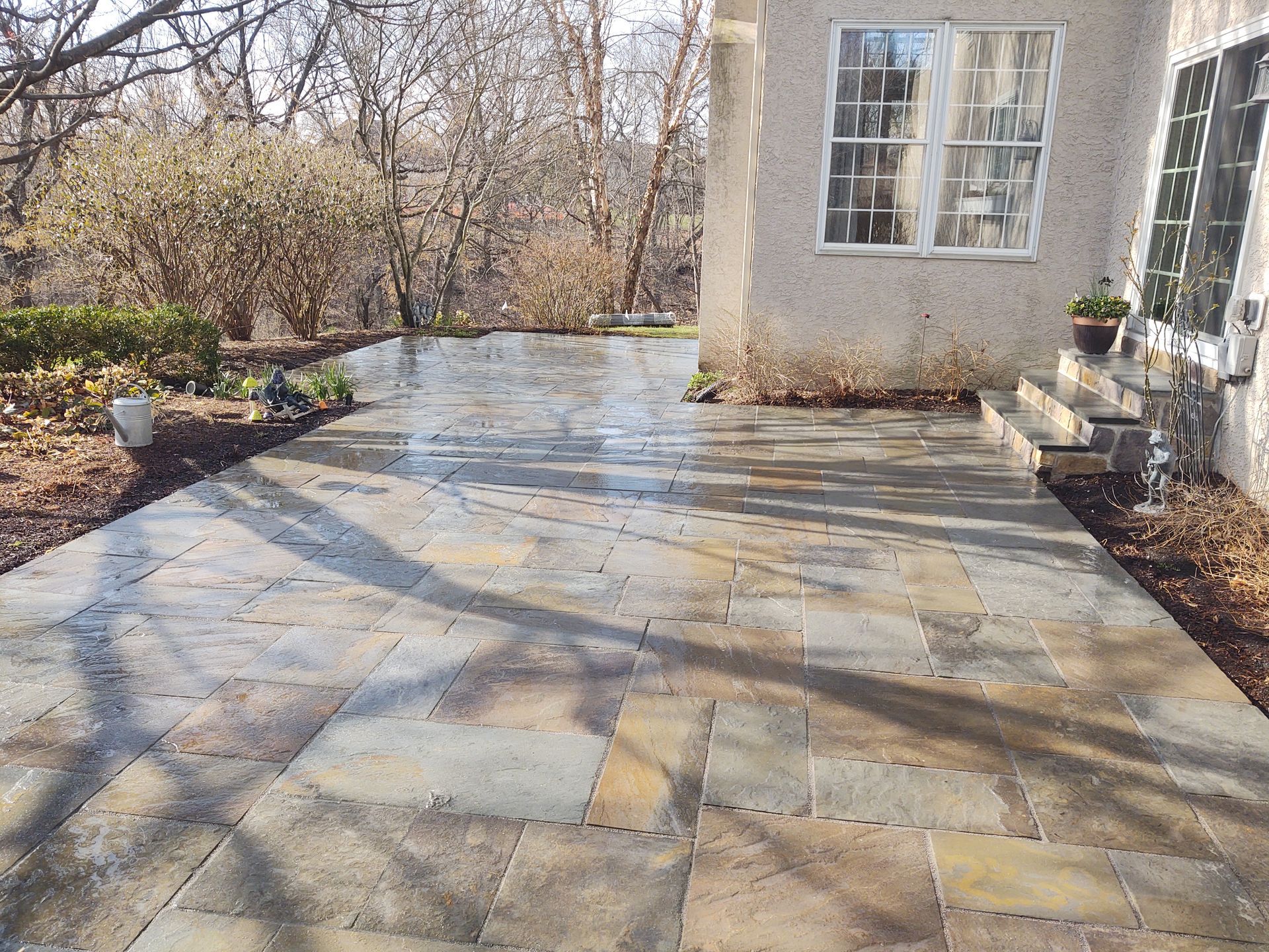 A patio in front of a house with trees in the background