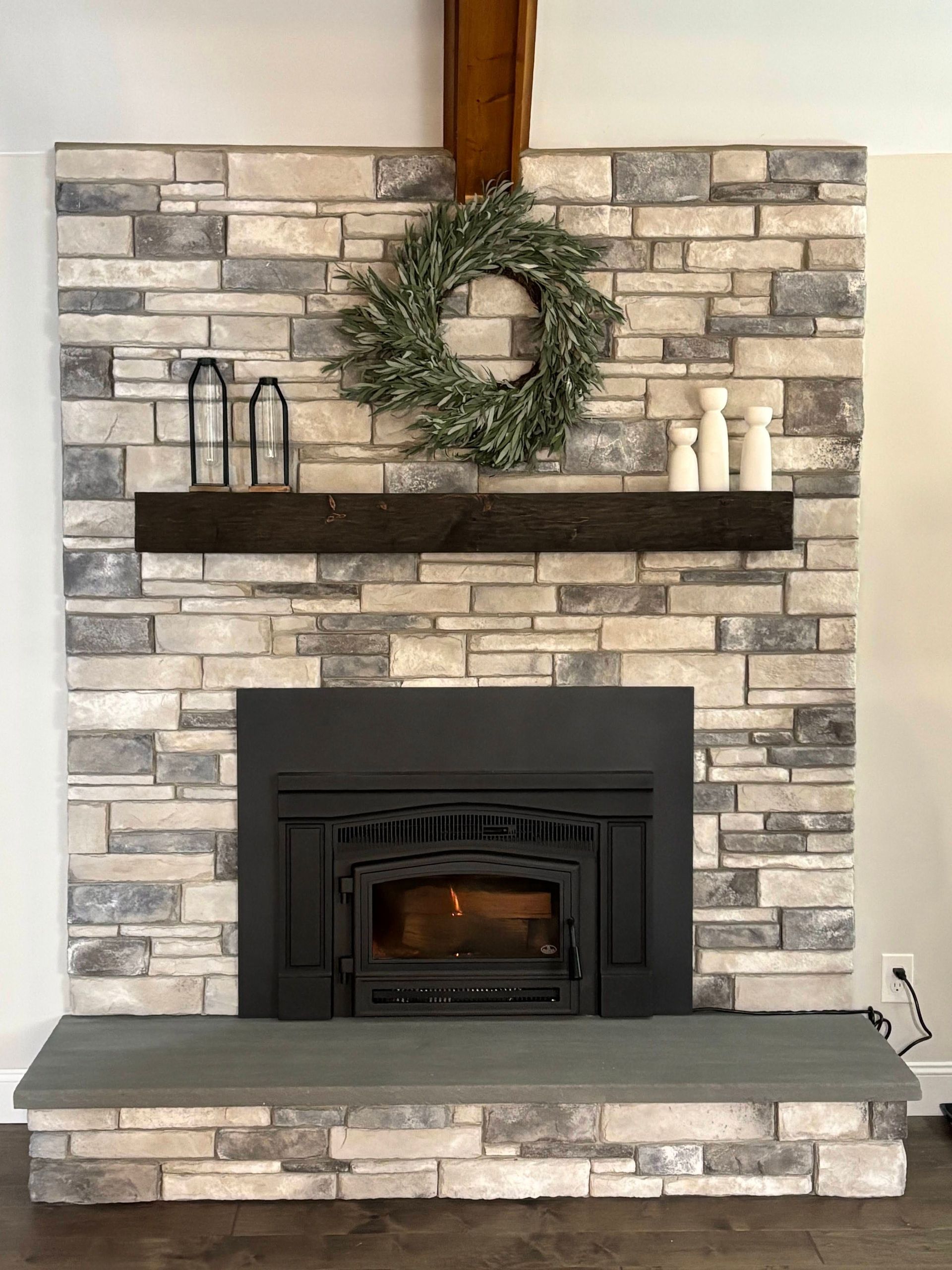 A fireplace with a wreath on top of it in a living room.
