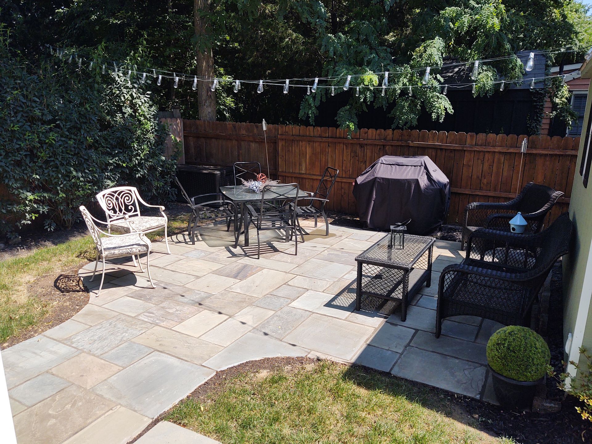 A patio with a table and chairs in a backyard