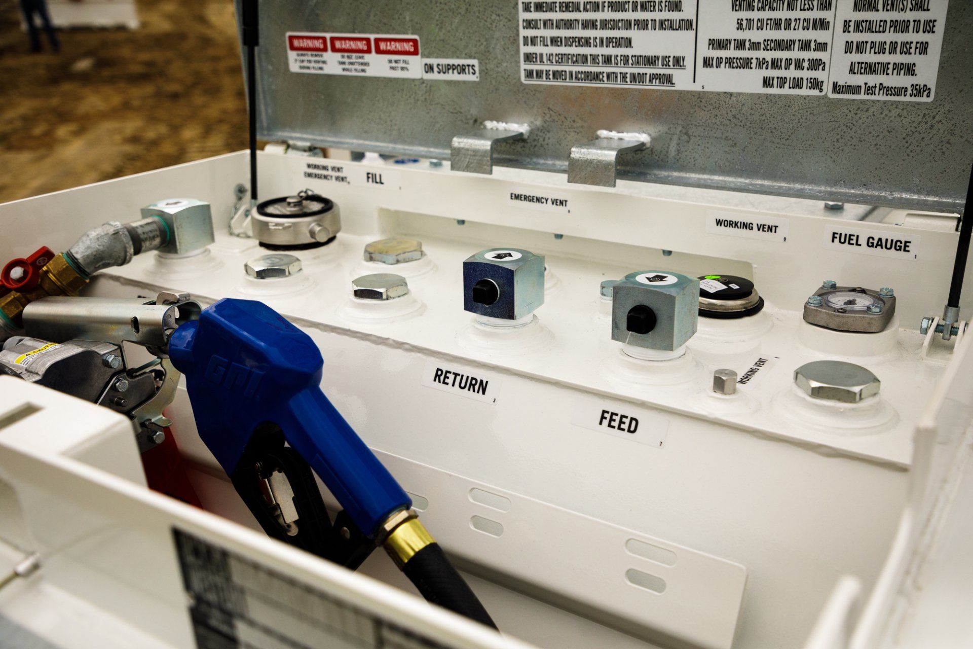 White fuel tank display with blue nozzle, parts, and labels.