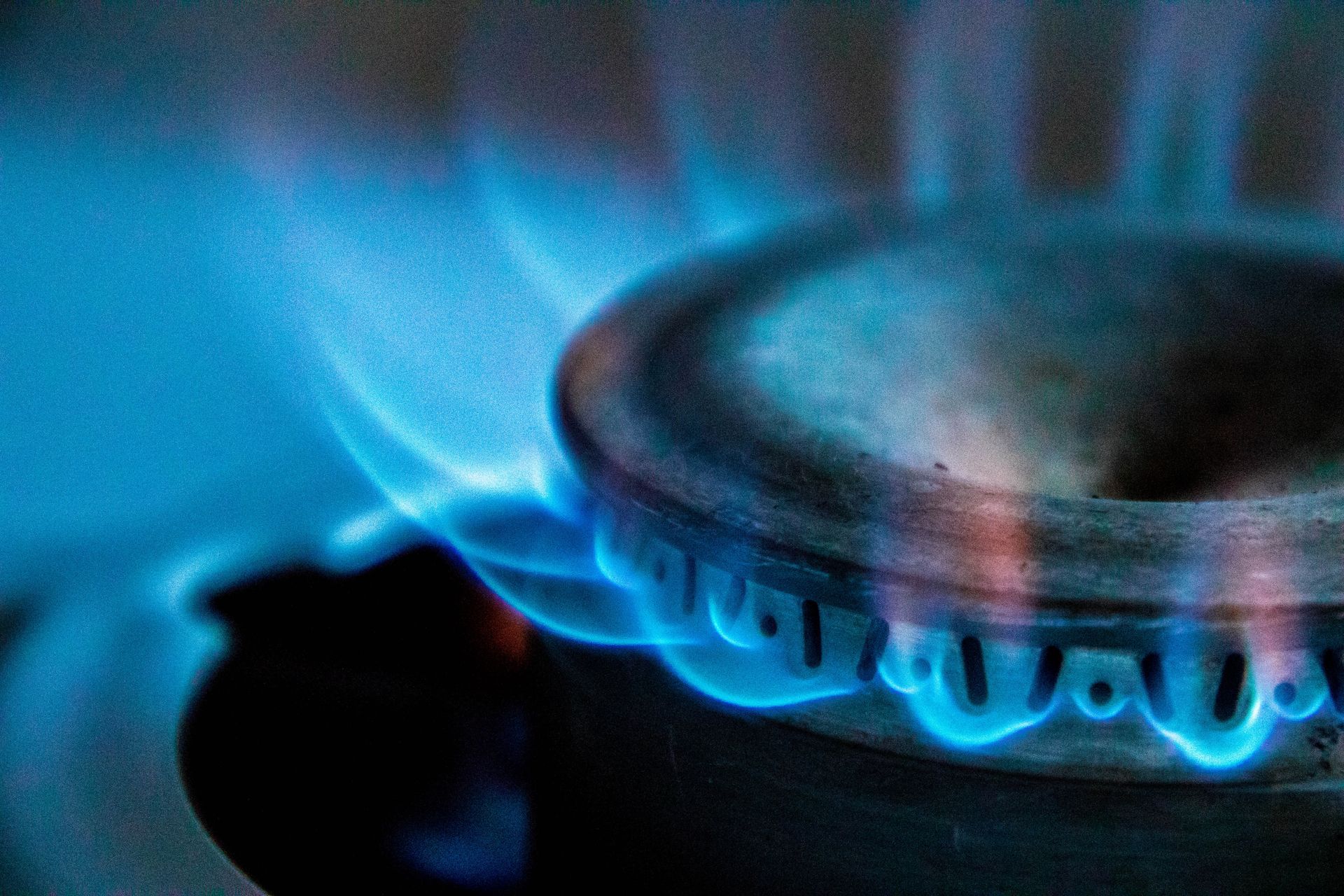 Close-up of blue gas flame burning on a kitchen stove burner. Close-up of blue gas flame burning on a kitchen stove burner.