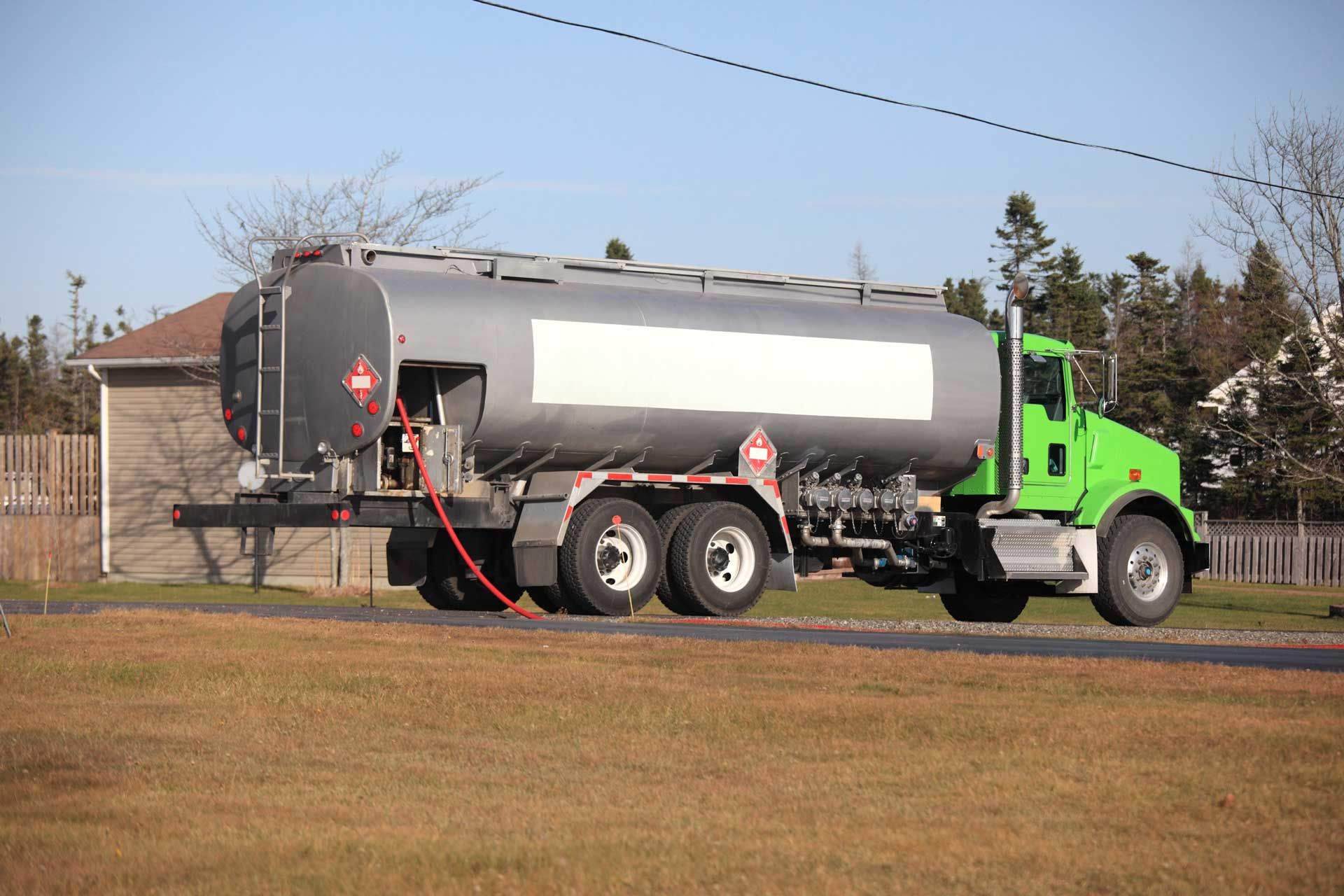 Home heating oil supplier truck parked on rural road, delivering fuel to remote homes safely. Home heating oil supplier truck parked on rural road, delivering fuel to remote homes safely.