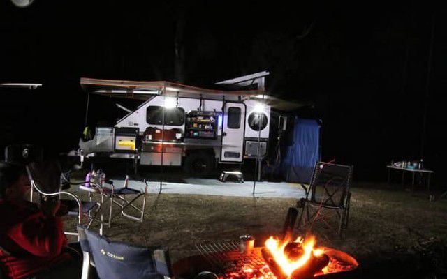 Experience The Allure of Our Camper Trailer Amidst a Crackling Campfire, Embodying The Essence of Outdoor Adventure - Quality Camper Trailers For Sale In Townsville