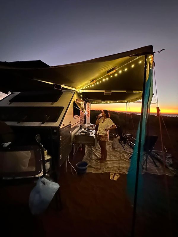 Gracefully Positioned Beneath a Sheltering Awning, a Woman Stands in Front of a Camper — Ozzie Camper Trailers in Mount Isa, QLD