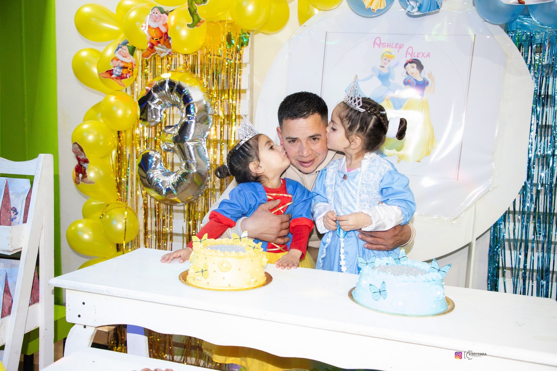 Un padre con dos niñas pequeñas, besándolo, celebrando un cumpleaños con pasteles y decoraciones.
