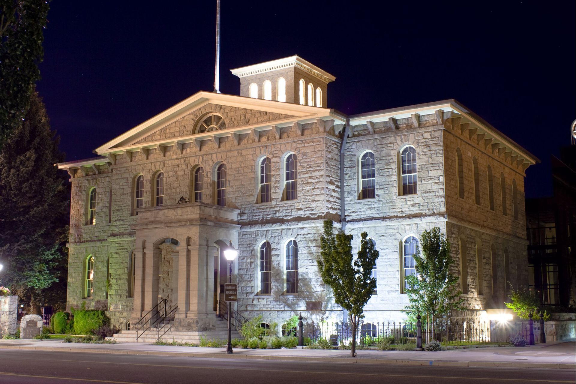 A large stone building is lit up at night.