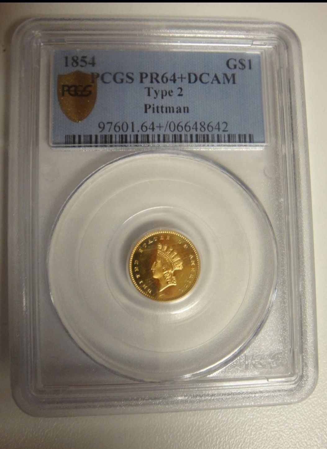 A gold coin in a plastic case with a label that says pcgs pr64 + dcam type 2