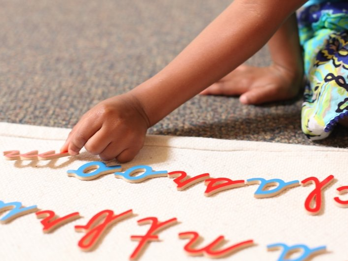 Child working with a Montessori language material