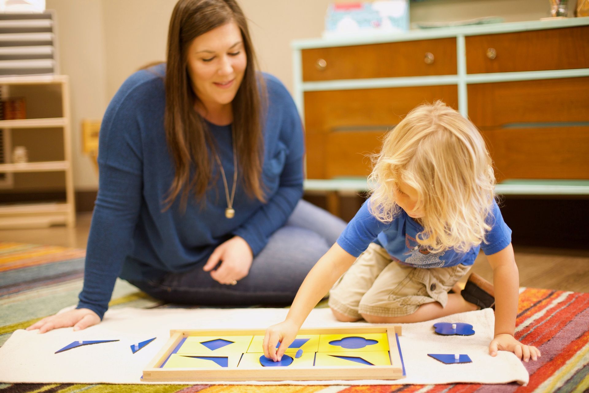 Guide and child in a Montessori classroom