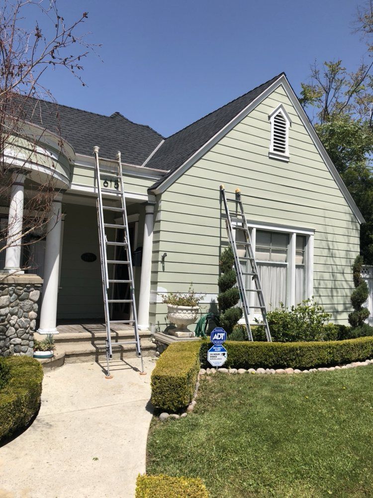 A house with a ladder on the front of it is being painted.
