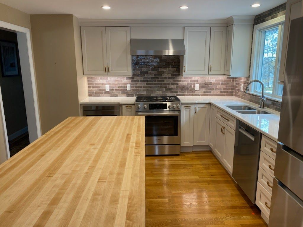 A kitchen with stainless steel appliances and a wooden counter top.