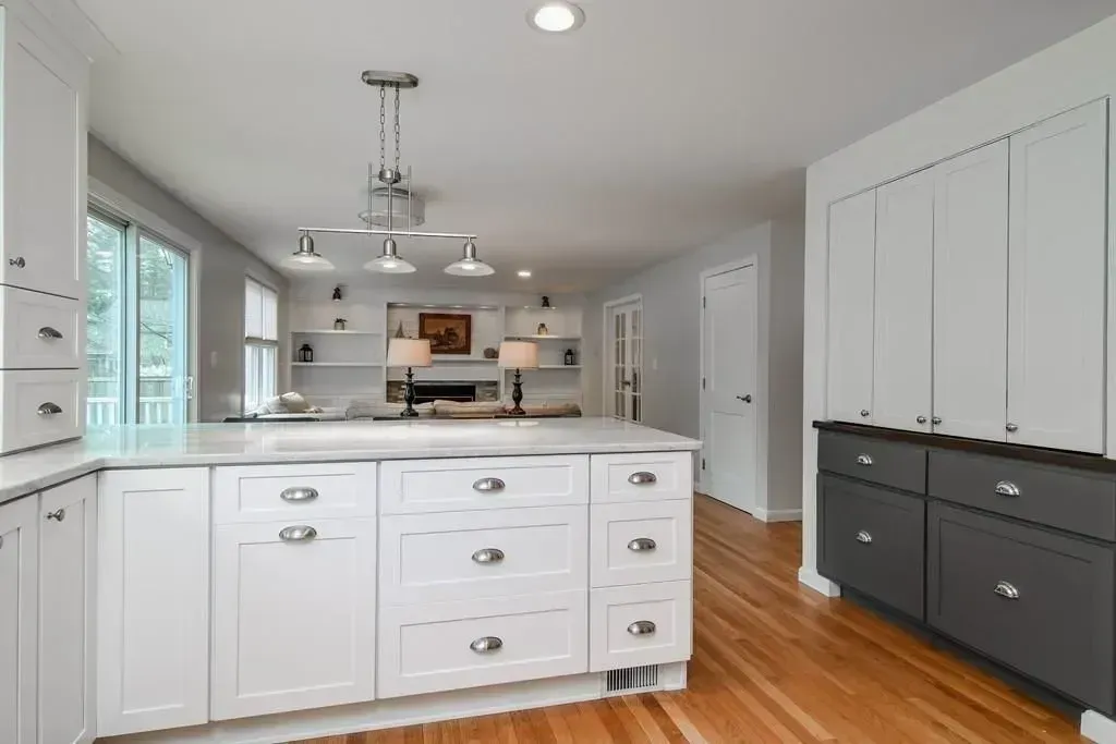 A kitchen with white cabinets and a large island