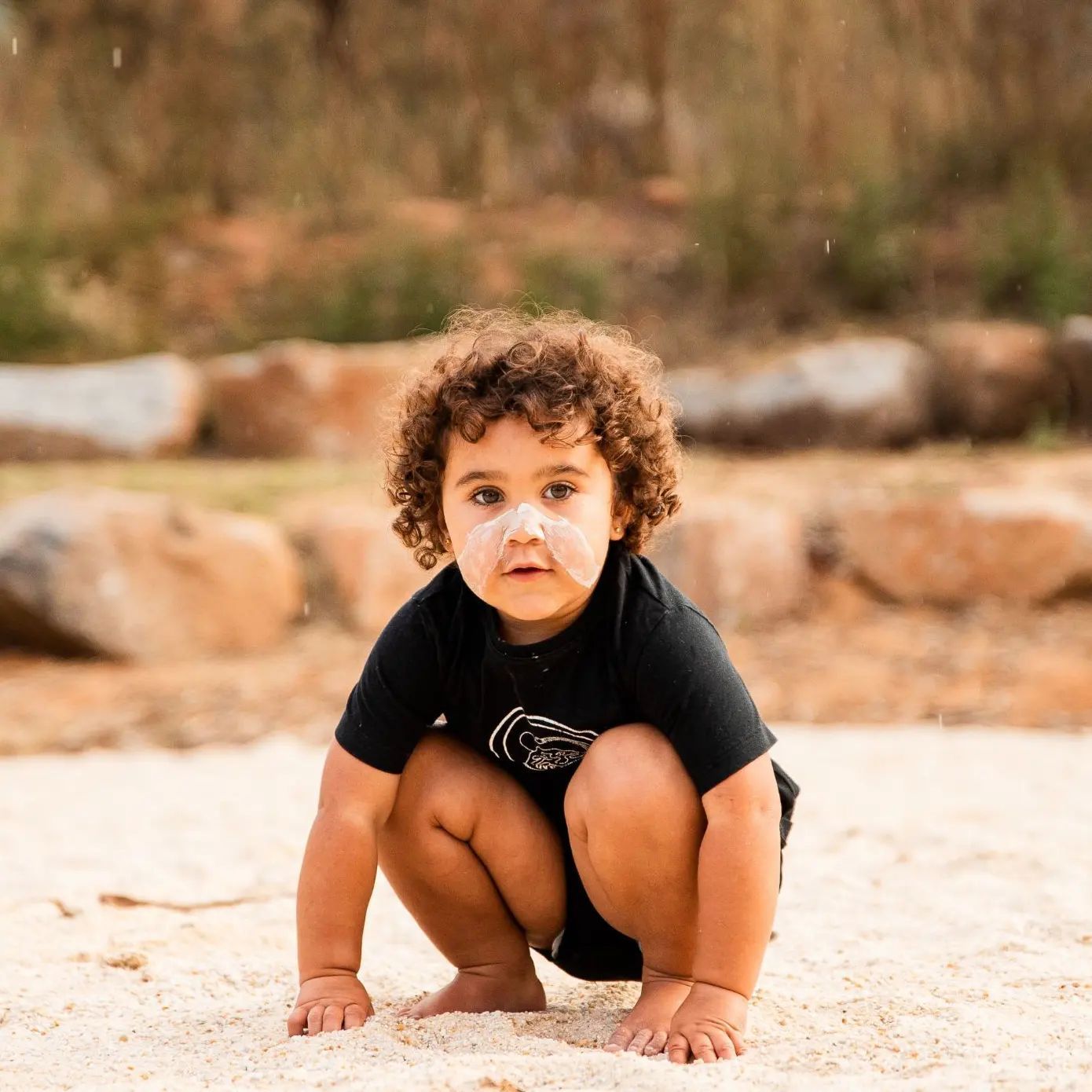 Toddler with White Face Paint Playing in the Beach — Dinawan's Connection in Dubbo, NSW