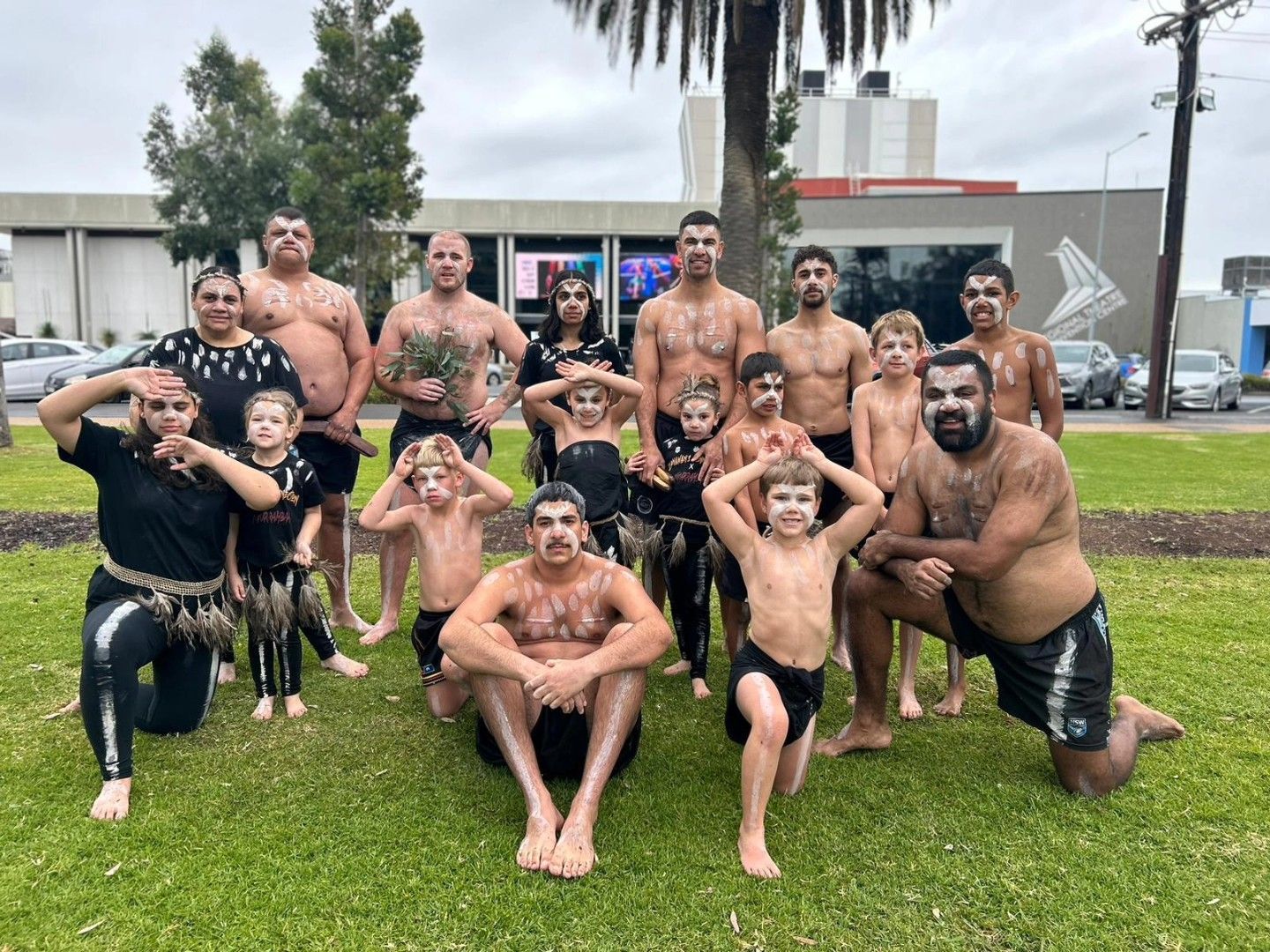 Group of People, Some Shirtless, Performing an Indigenous Dance Outdoors on Grass — Dinawans Connection in Albury, NSW